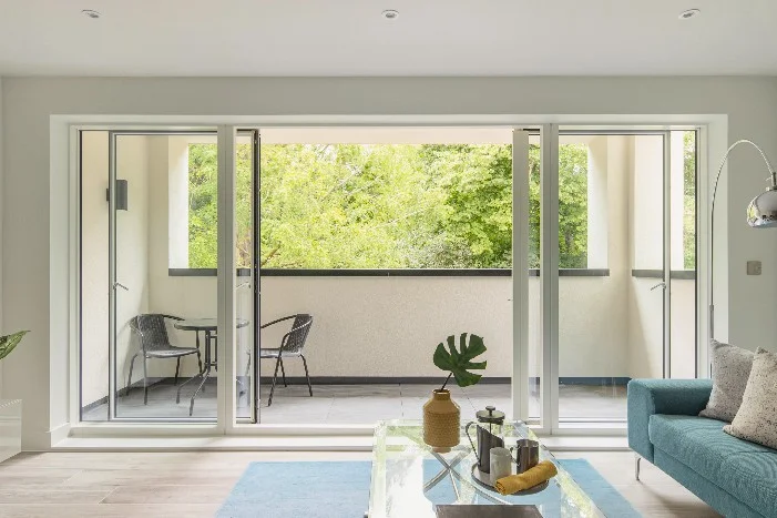 Wohnzimmer mit Balkon und Bäumen